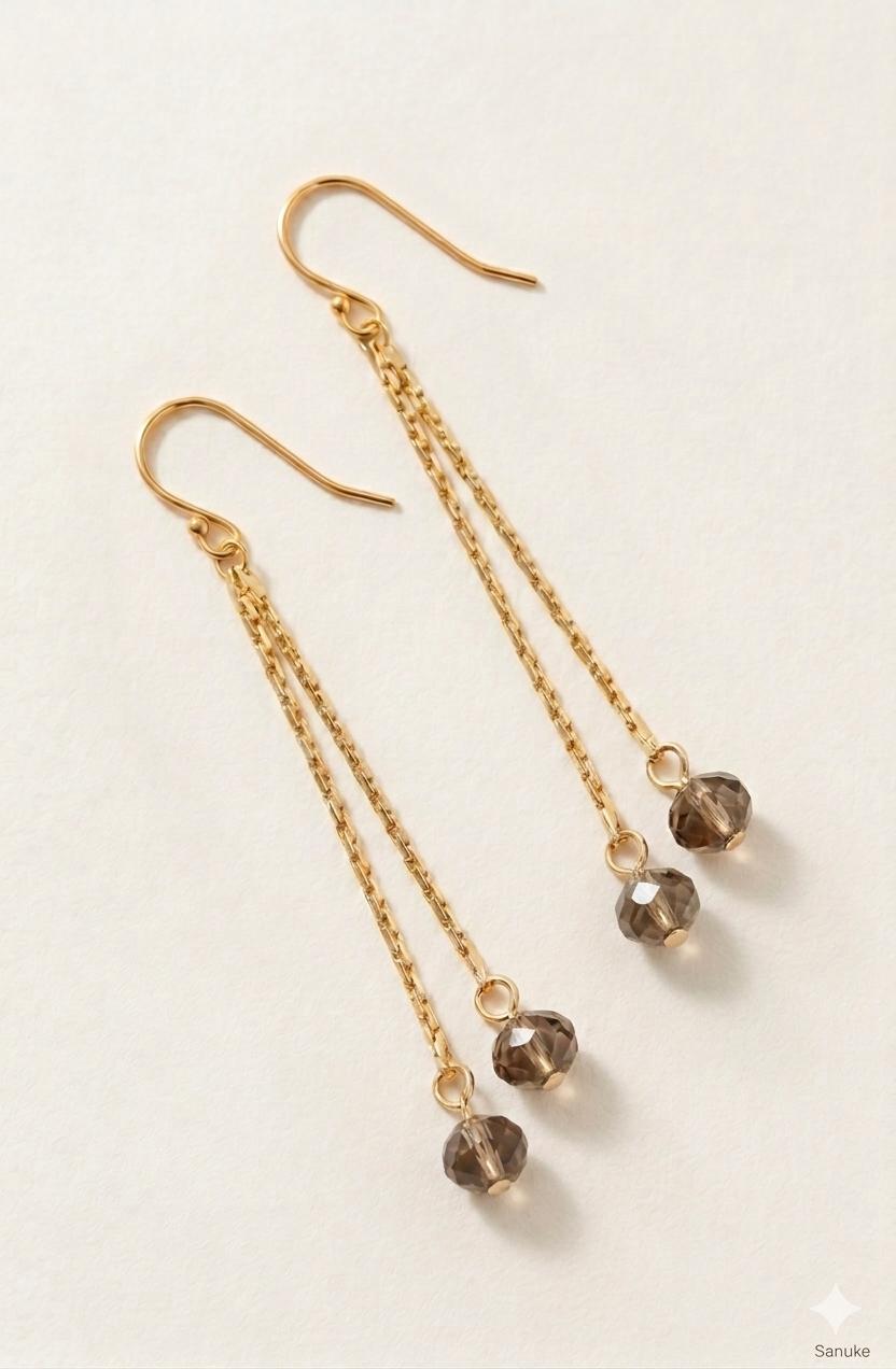 Pendientes Fleco Humo | SANUKE Pendientes Fleco Humo SANUKE con cadenas doradas y cristales facetados color humo, diseño largo y elegante con movimiento.