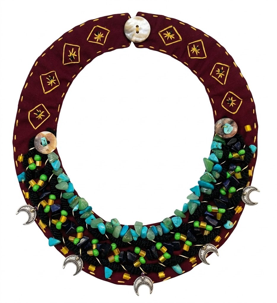 Collar Bordado "Luna Turquesa" - Colección Sanuke Collar pechera de tela artesanal de Sanuke en color granate, bordado a mano con hileras de piedras turquesas, cuentas de macramé y dijes de media luna plateados."